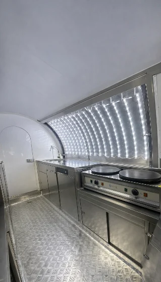 Intérieur : deux crêpières sur un meuble inox, plan de travail et évier